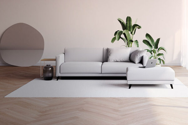 Un salon à la déco scandinave avec un canapé d'angle gris clair et un tapis blanc à poils longs.