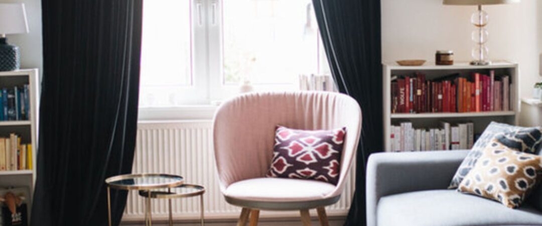 Un maison cocooning avec un salon cosy, comprenant un canapé gris clair et un fauteuil vieux rose.