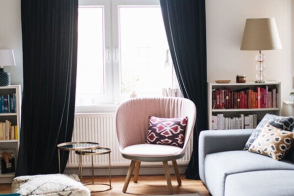 Un maison cocooning avec un salon cosy, comprenant un canapé gris clair et un fauteuil vieux rose.