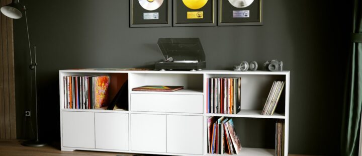 Un meuble vynile blanc composé de compartiments ouverts et fermés.