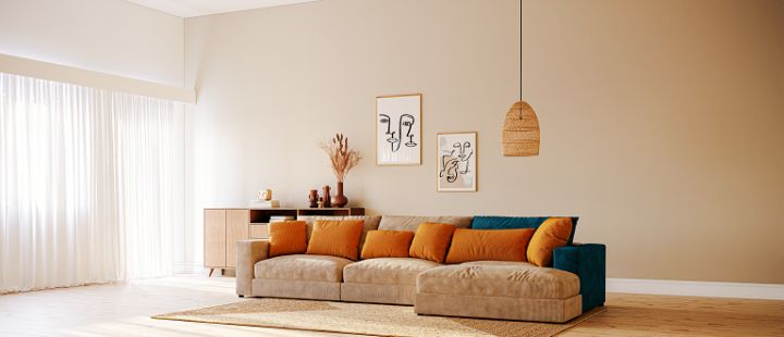 Un canapé en velours côtelé beige avec des coussins orange.