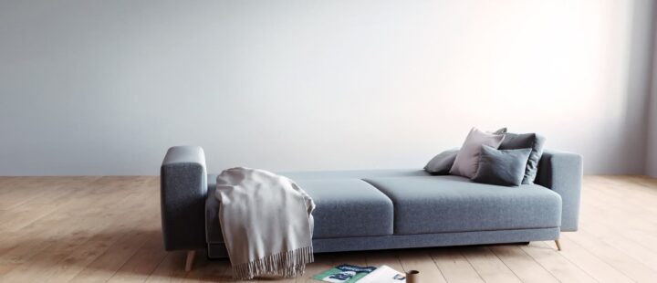 Un canapé convertible gris ouvert en position couchage.