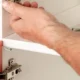 Gros plan d'une personne en train de fixer une étagère.