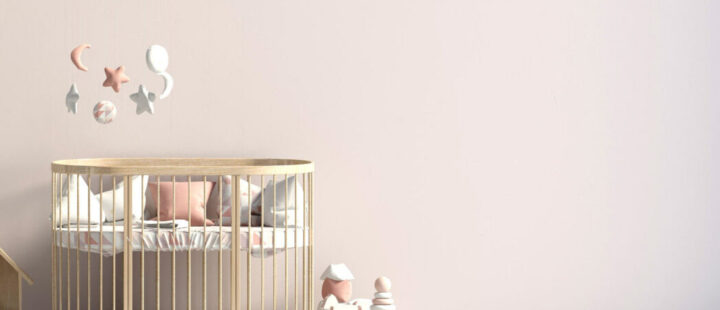 Un lit pour enfant en bois avec un mobile au-dessus.