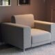 Un fauteuil gris avec de larges accoudoirs.