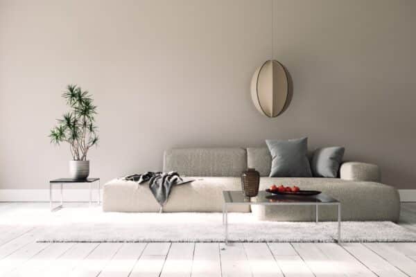 Un salon moderne chic avec un canapé beige et une table basse aux pieds en métal.