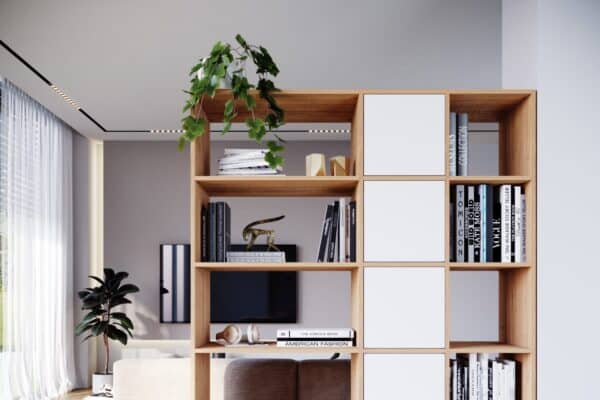 Une bibliothèque en bois et blanche utilisée comme séparateur de pièce.